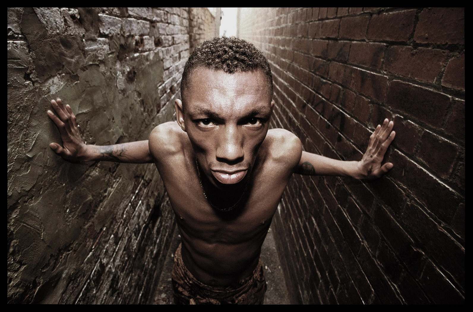 Tricky with outstretched arms in a narrow brick alley