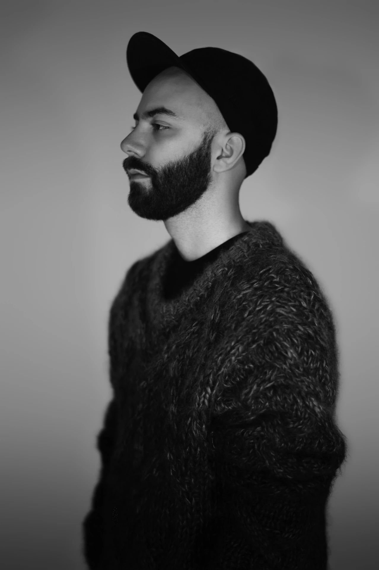Woodkid wearing a cap in a black-and-white portrait