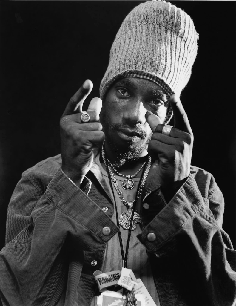 Sizzla Kalonji w wysokiej wełnianej czapce na czarno-białym portrecie