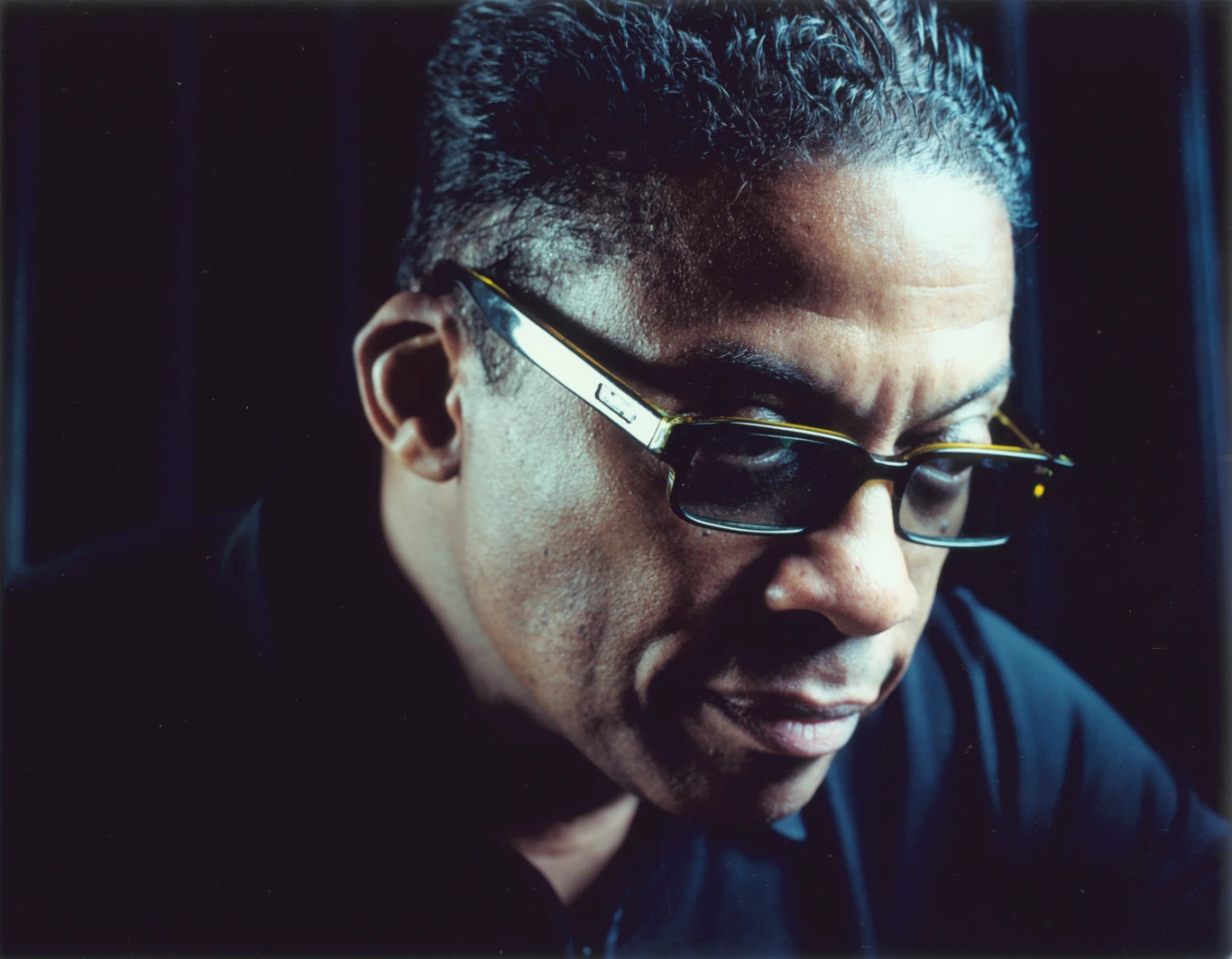 Herbie Hancock w okularach przeciwsłonecznych na ciemnym portrecie