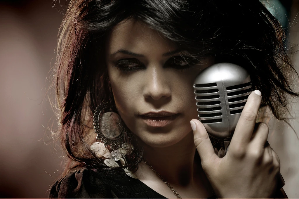 Yasmin Levy holding a silver microphone beside her face