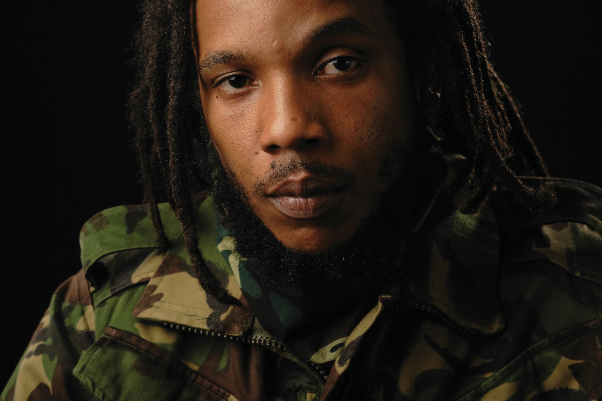 Stephen Marley w kurtce moro na ciemnym tle
