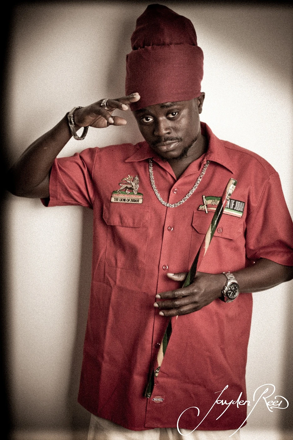 A reggae vocalist wearing a red shirt and a tall hat