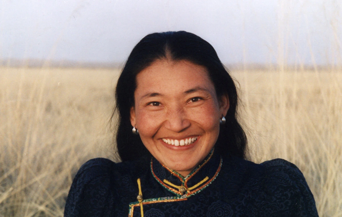 Urna wearing traditional clothing against a grassland landscape