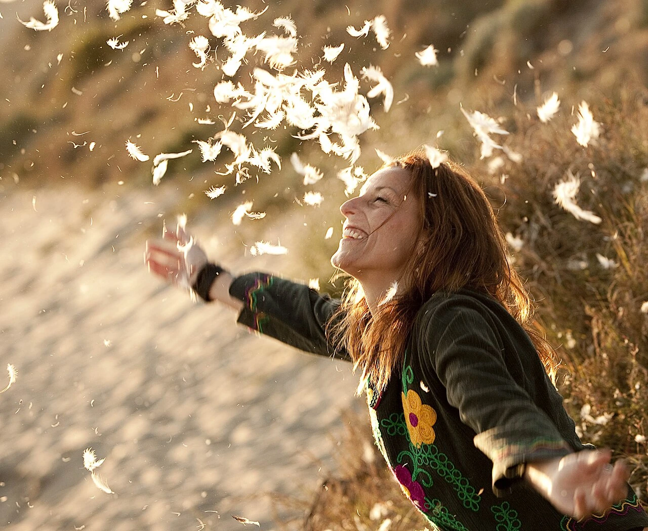Lamari z zespołu Chambao z rozwianymi włosami wśród piór
