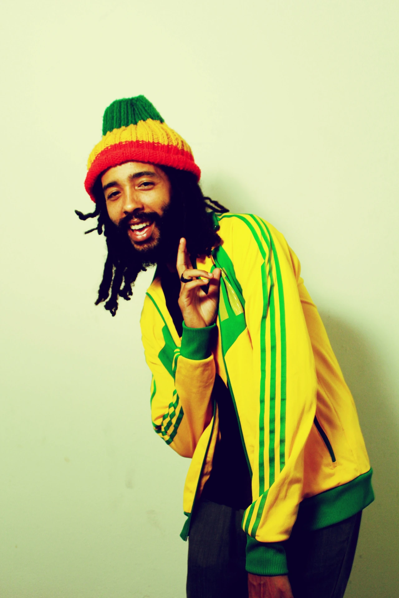 Protoje wearing a yellow shirt and a Rastafarian-coloured hat