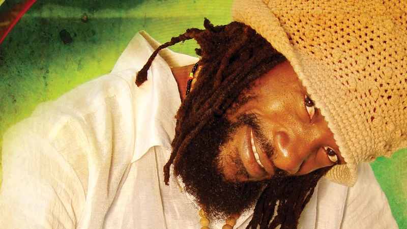 Uśmiechnięty wokalista reggae w słomkowym kapeluszu
