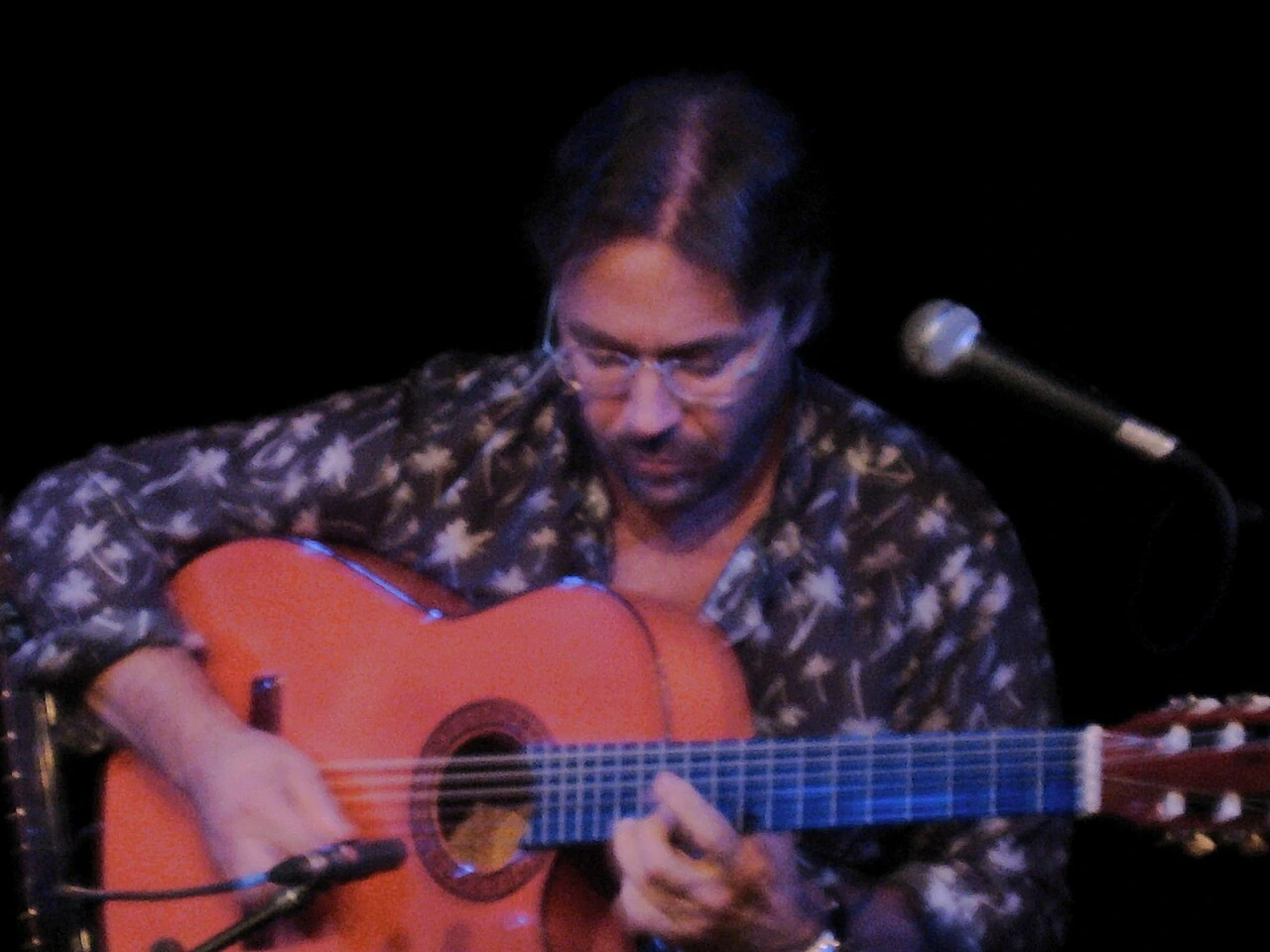 Al Di Meola playing an acoustic guitar at a concert in 2009