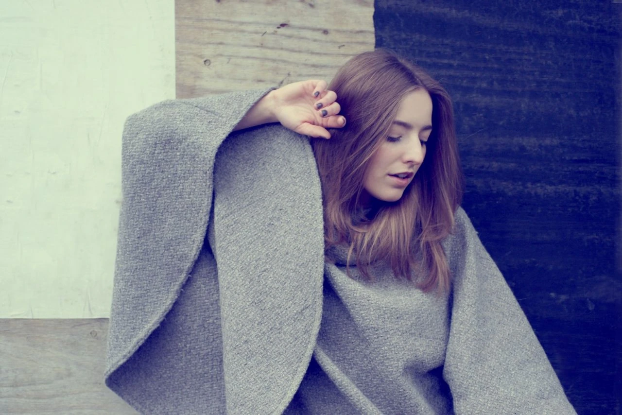 Kari Amirian wearing a grey coat and leaning against a wall