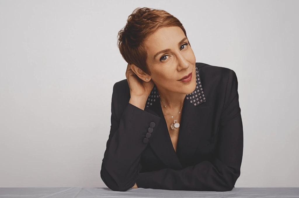 Stacey Kent leaning on a light-coloured surface in a portrait wearing a dark jacket