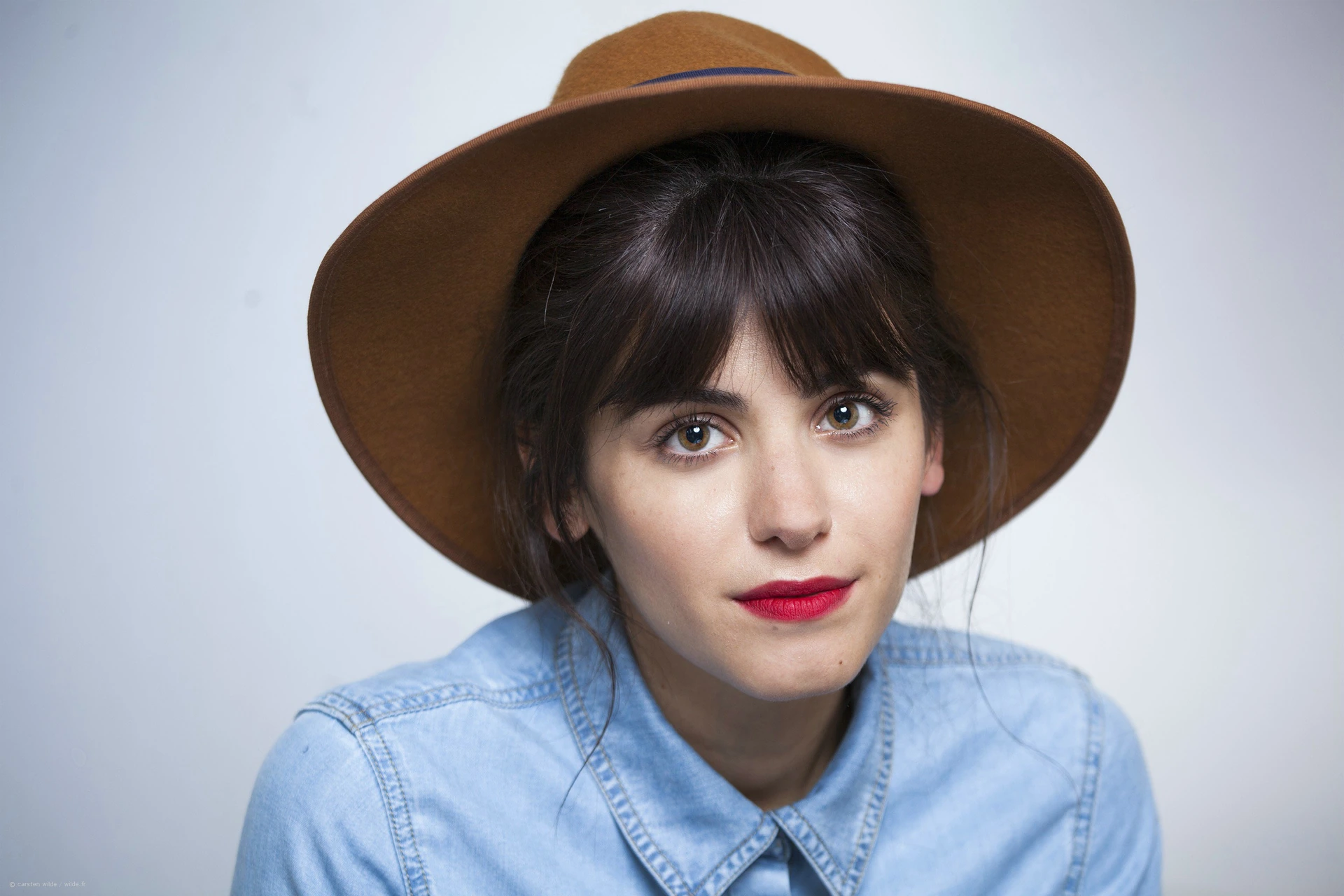 Katie Melua w brązowym kapeluszu i jasnoniebieskiej koszuli