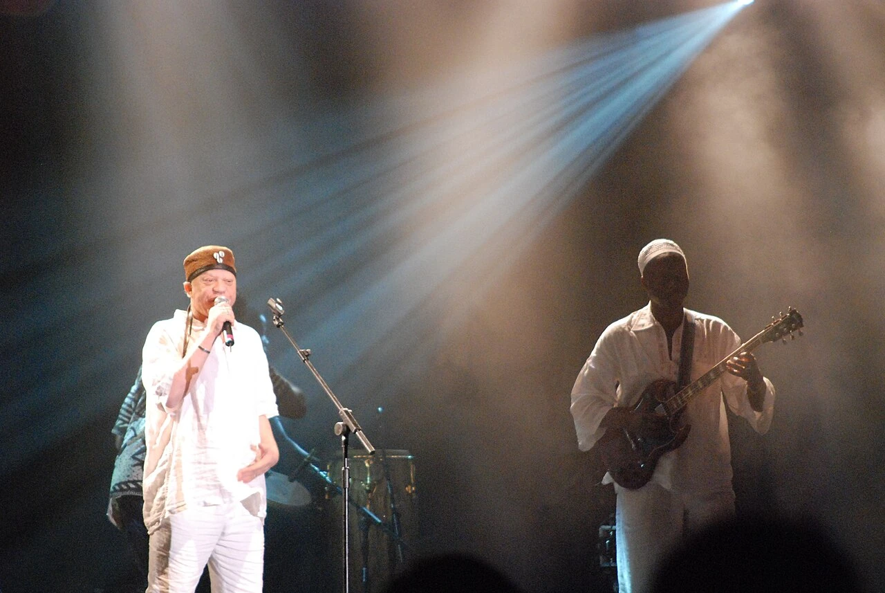 Salif Keita w jasnym stroju przy mikrofonie na scenie WOMAD w 2010 roku