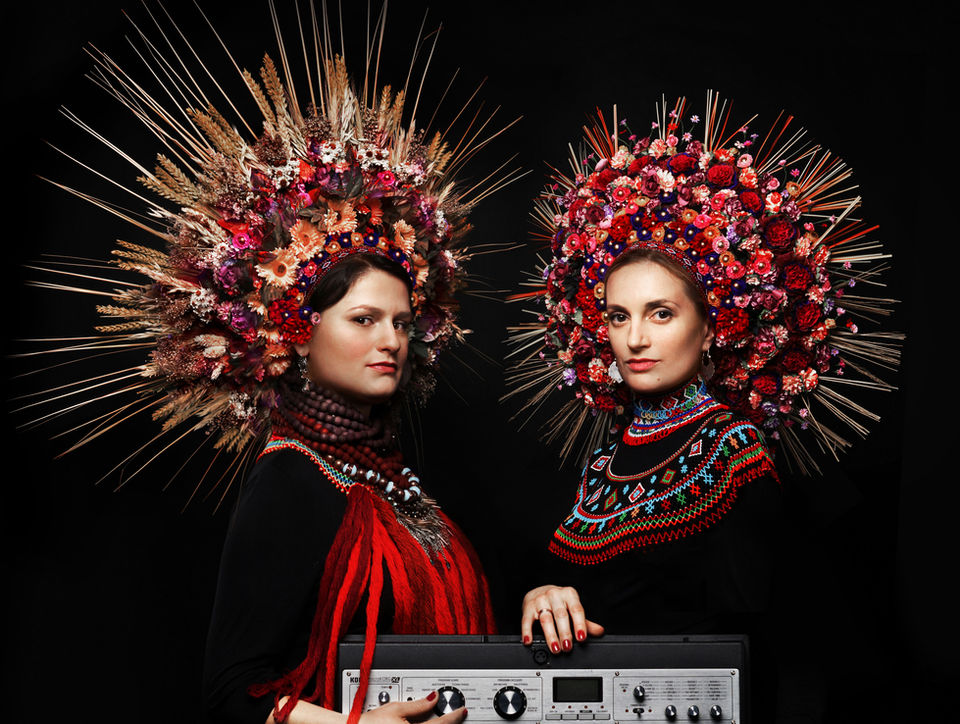 Dagadana singers wearing floral headdresses with a keyboard instrument