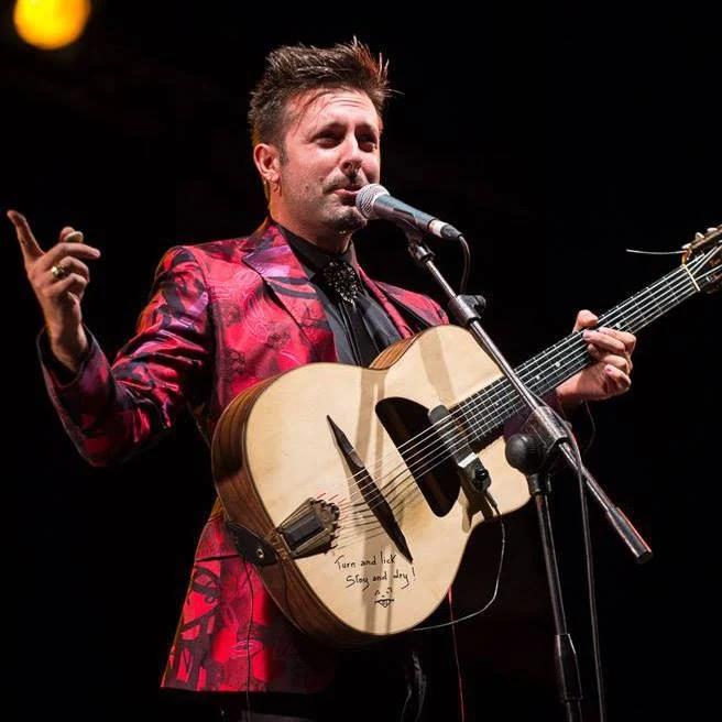 Dario Pinelli with his guitar at the microphone